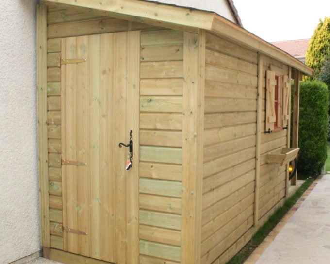 Abri de jardin en bois adossé à une maison.