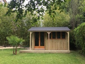 Abri de jardin en bois dans un environnement verdoyant luxuriant