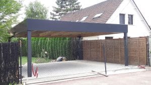 Abri de voiture moderne gris foncé devant une maison résidentielle.