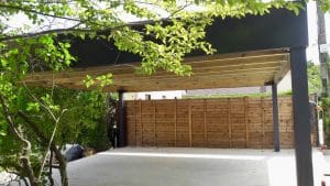 Carport moderne en bois et métal avec clôture en bois.