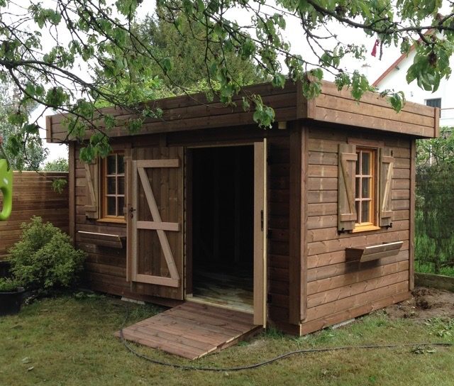 Abri de jardin en bois marron, porte ouverte.