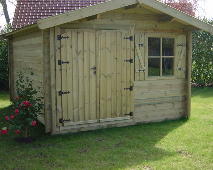 Abri de jardin en bois avec fleurs roses sur pelouse verte.