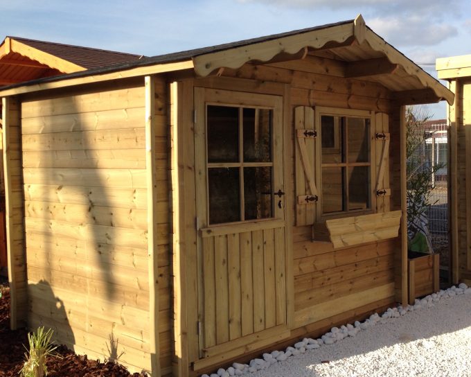 Abri de jardin en bois clair avec porte, fenêtre et jardinière.