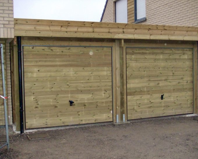 Deux portes de garage en bois sous un abri.